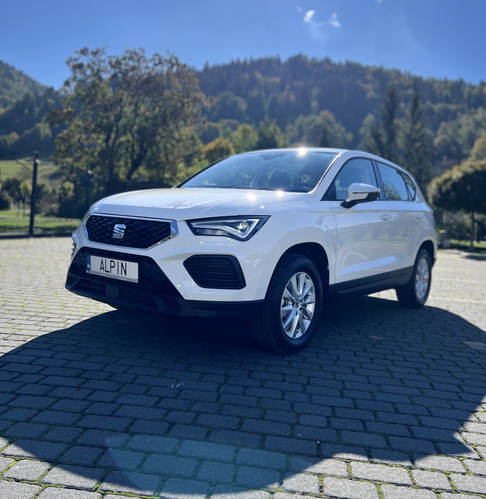 Seat Ateca, ładna pogoda, las w tle, wypożyczalnia samochodów Alpin